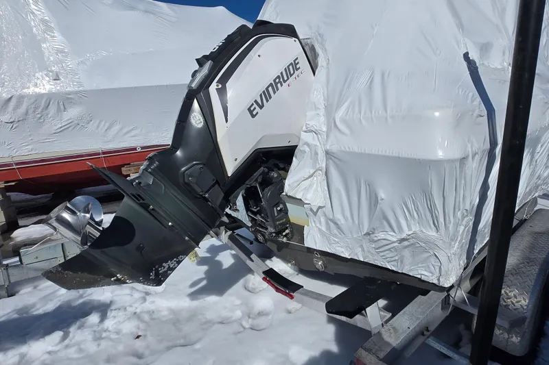 Slide: The Image of 2018 Clearwater 2000 Center Console boat with Evinrude engine, covered in snow. - 6
