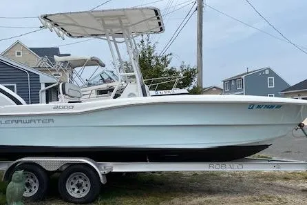 The Image of 2018 Clearwater 2000 Center Console boat on trailer, parked near houses. - 0