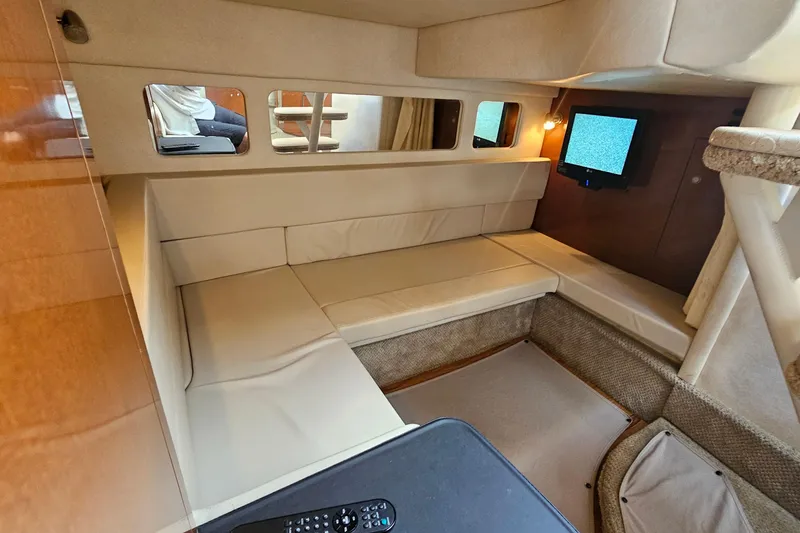 Slide: The Image of Interior of 2008 Sea Ray Sundancer 310 with beige seating and mounted TV. - 11