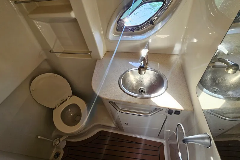 Slide: The Image of 2008 Sea Ray Sundancer 310 bathroom with sink, toilet, and porthole window. - 12