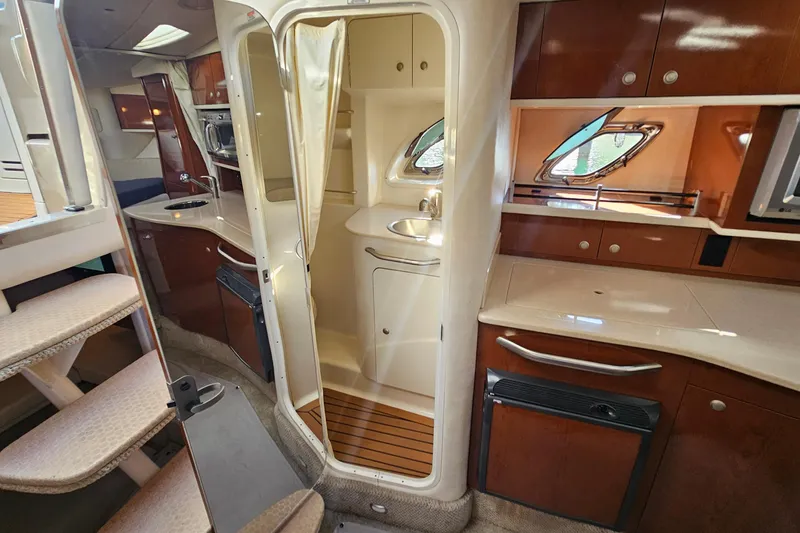 Slide: The Image of 2008 Sea Ray Sundancer 310 interior with kitchenette, stairs, and wooden cabinetry. - 13
