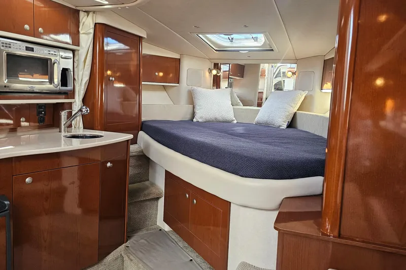 Slide: The Image of Luxurious 2008 Sea Ray Sundancer 310 cabin interior with bed, kitchenette, and wood finishes. - 15