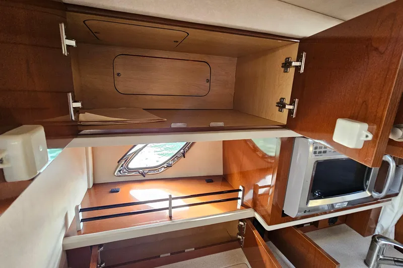Slide: The Image of 2008 Sea Ray Sundancer 310 interior kitchen with wooden cabinets and microwave. - 25