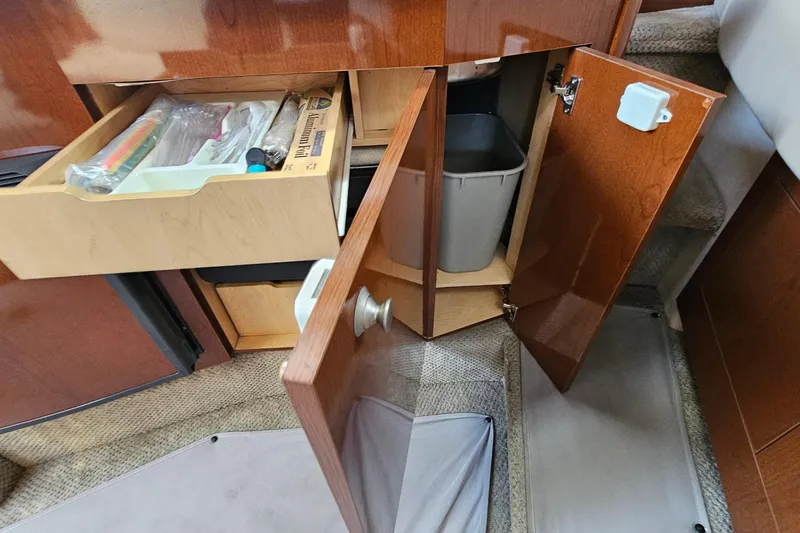 Slide: The Image of 2008 Sea Ray Sundancer 310 interior storage with open cabinets and drawers. - 26