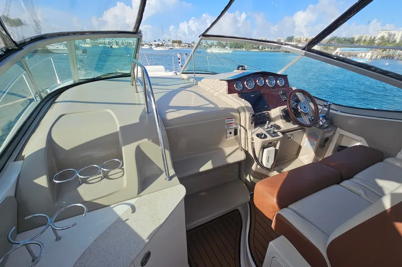Slide: The Image of 2008 Sea Ray Sundancer 310 cockpit with steering wheel, gauges, and seating, overlooking marina. - 36