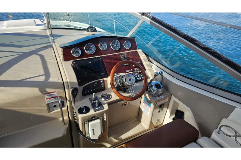 Slide: The Image of 2008 Sea Ray Sundancer 310 helm with wood accents and modern controls on open water. - 42