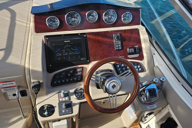 Slide: The Image of 2008 Sea Ray Sundancer 310 helm with wood accents and modern navigation controls. - 45