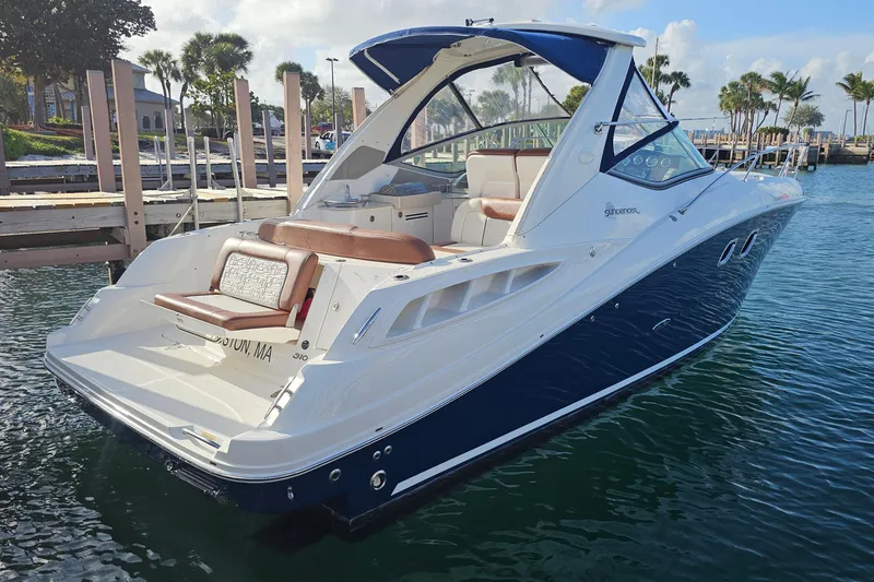Slide: The Image of 2008 Sea Ray Sundancer 310 boat docked in a marina, featuring sleek design and comfortable seating. - 50