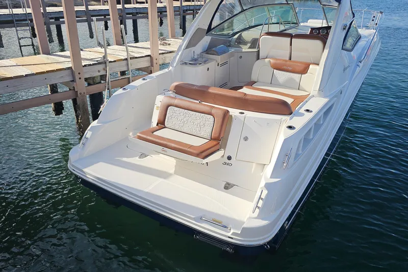 Slide: The Image of 2008 Sea Ray Sundancer 310 boat docked, featuring spacious seating and sleek design. - 51