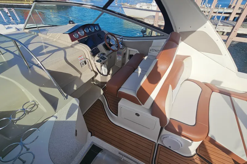 Slide: The Image of 2008 Sea Ray Sundancer 310 cockpit with brown and white seating, overlooking marina. - 52