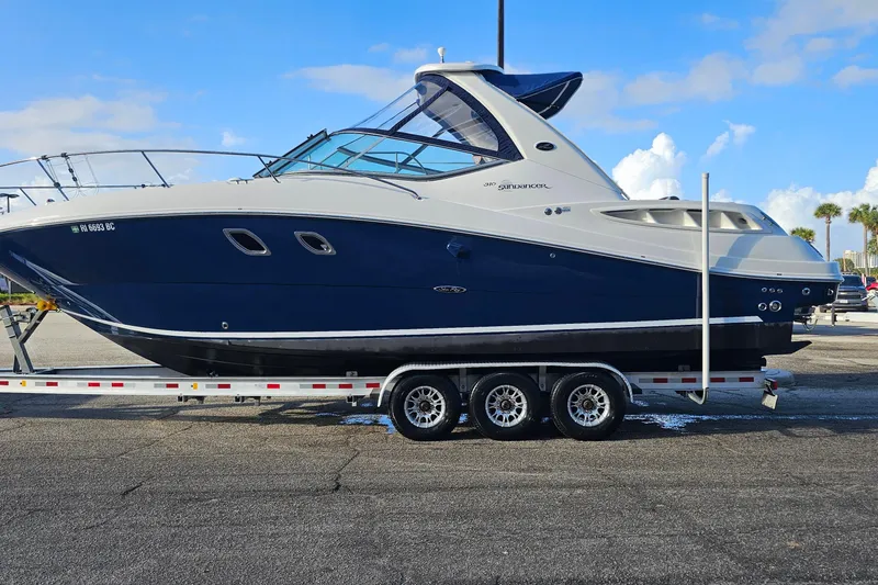 Slide: The Image of 2008 Sea Ray Sundancer 310 boat on trailer, parked outdoors under blue sky. - 61