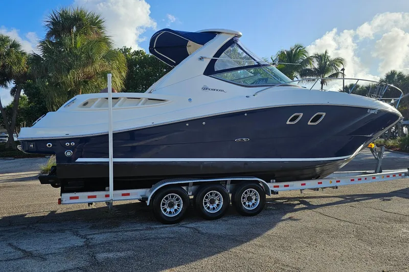 Slide: The Image of 2008 Sea Ray Sundancer 310 boat on trailer, parked with palm trees in background. - 66