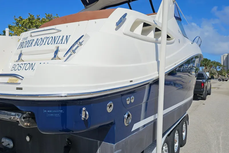 Slide: The Image of 2008 Sea Ray Sundancer 310 boat on trailer, labeled "The Proper Bostonian," parked outdoors. - 7