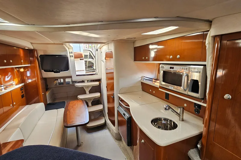 Slide: The Image of 2008 Sea Ray Sundancer 310 interior with kitchen, seating, and entertainment area. - 8