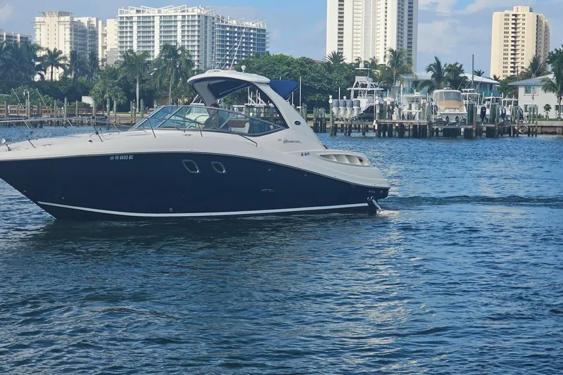 Slide: The Image of 2008 Sea Ray Sundancer 310 cruising on a sunny day near a marina with tall buildings. - 82