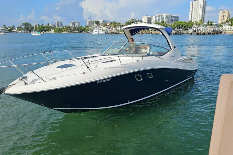 Slide: The Image of 2008 Sea Ray Sundancer 310 yacht on calm water with city skyline background. - 84