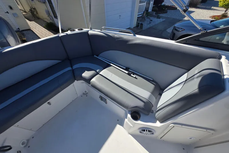 Slide: The Image of 2023 NauticStar 223 DC boat interior with gray seating and cup holders. - 10