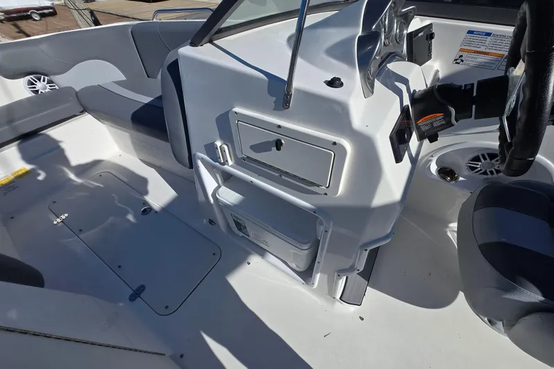 Slide: The Image of 2023 NauticStar 223 DC boat interior with steering wheel and seating area. - 11