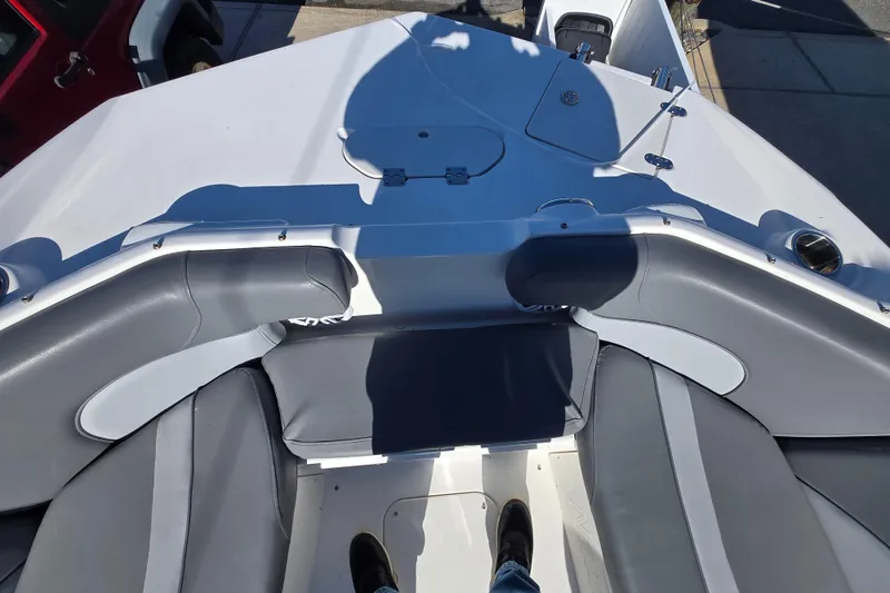 Slide: The Image of 2023 NauticStar 223 DC boat interior with gray seating and deck view. - 13