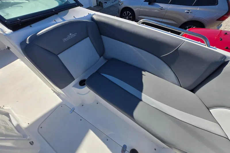 Slide: The Image of 2023 NauticStar 223 DC boat interior with gray seating and logo detail. - 16