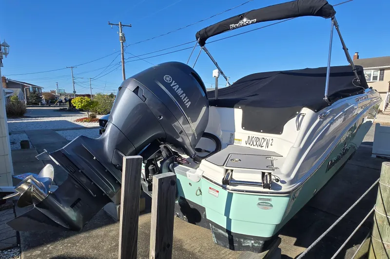 Slide: The Image of 2023 NauticStar 223 DC boat with Yamaha outboard motor, docked and covered. - 19