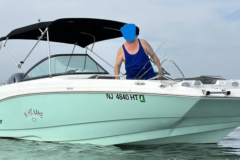 Slide: The Image of 2023 NauticStar 223 DC boat on water with person fishing, NJ registration visible. - 3