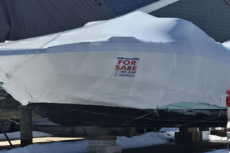 Slide: The Image of 2023 NauticStar 223 DC boat covered and for sale in snowy setting. - 6