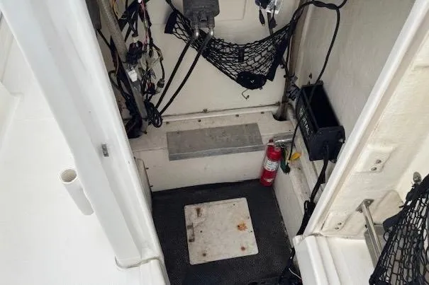 Slide: The Image of 2018 Robalo R180 Center Console storage area with fire extinguisher and wiring. - 12