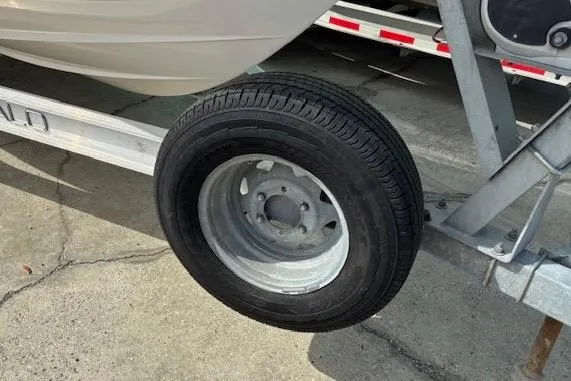 Slide: The Image of Trailer wheel of a 2018 Robalo R180 Center Console boat on concrete surface. - 5