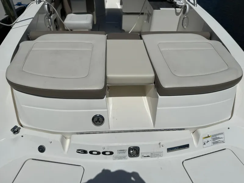 Slide: The Image of 2013 Sea Ray 300 SLX boat with cushioned seating and storage compartments. - 12