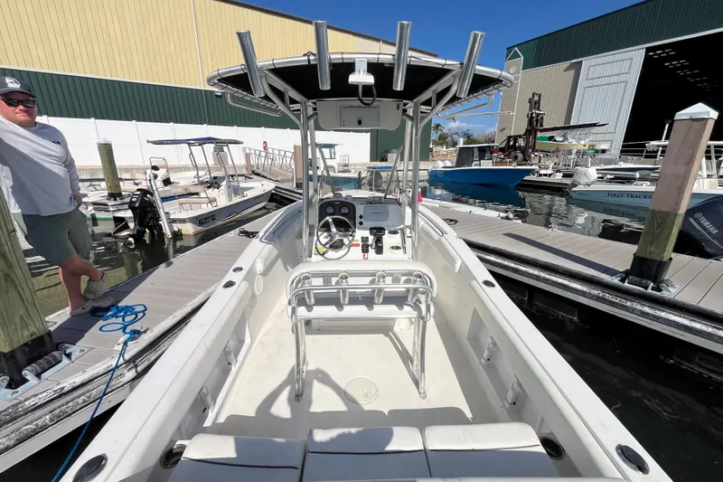 Slide: The Image of 2014 Sea Hunt Ultra 211 boat docked at marina, featuring center console and T-top. - 13