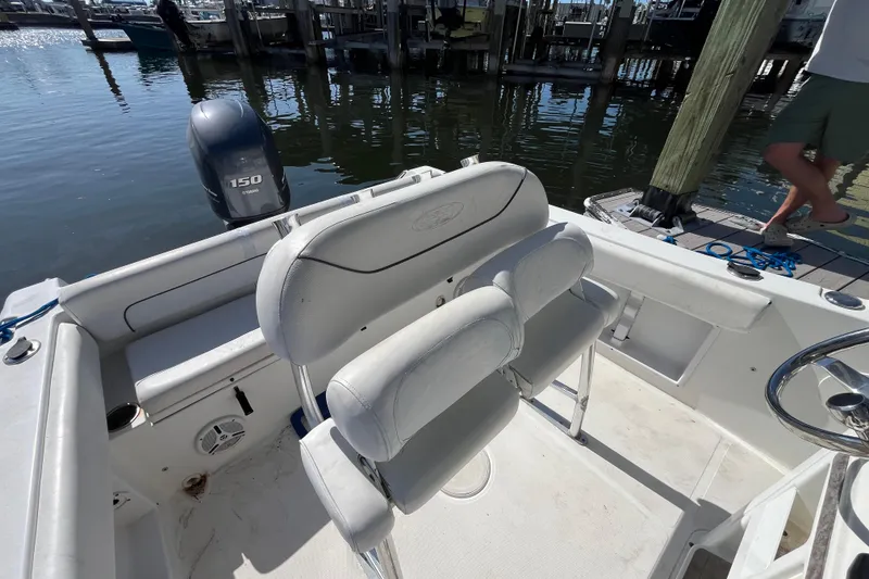 Slide: The Image of 2014 Sea Hunt Ultra 211 boat interior with Yamaha 150 engine at dock. - 16