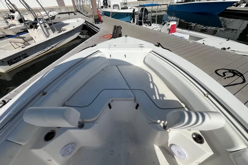 Slide: The Image of 2014 Sea Hunt Ultra 211 boat interior at dock, featuring spacious seating and clean design. - 20