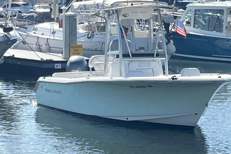 Slide: The Image of 2014 Sea Hunt Ultra 211 boat docked in a marina, displaying an American flag. - 5