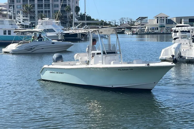 Slide: The Image of 2014 Sea Hunt Ultra 211 boat in marina, calm waters, sunny day. - 6
