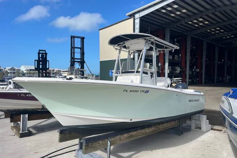 Slide: The Image of 2014 Sea Hunt Ultra 211 boat on a dock, under a clear blue sky. - 7