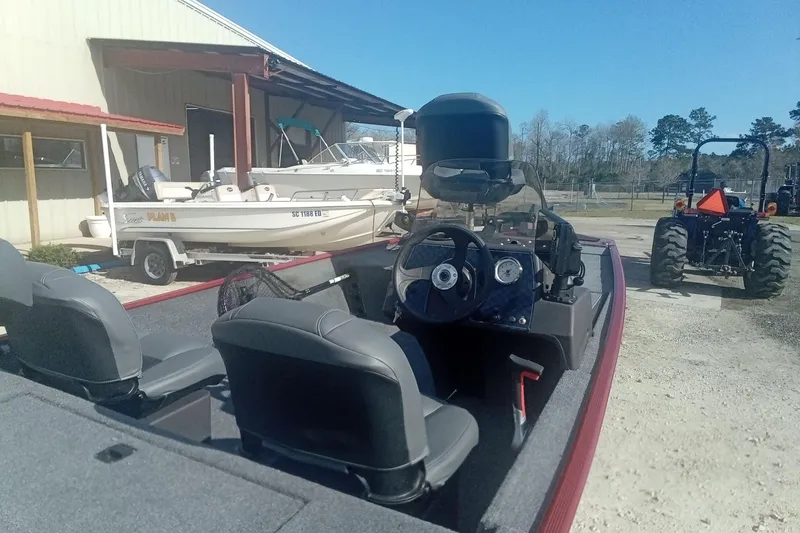 Slide: The Image of 2023 Tracker Bass Tracker Classic XL boat parked outdoors near a building and tractor. - 9