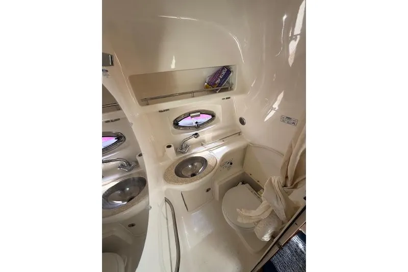 Slide: The Image of 2009 Chaparral Signature 290 bathroom with sink, toilet, and porthole window. - 4