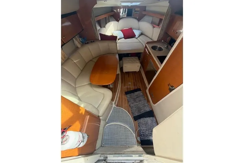 Slide: The Image of 2009 Chaparral Signature 290 interior with cozy seating, wooden flooring, and compact kitchenette. - 8