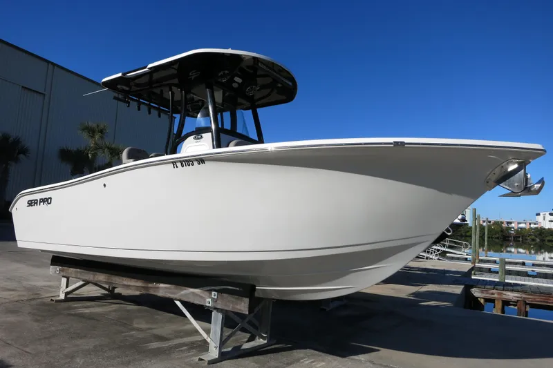 Slide: The Image of 2021 Sea Pro 239 Deep V CC boat on display, dockside under clear blue sky. - 2