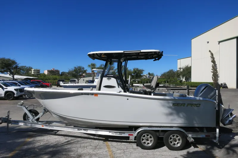 Slide: The Image of 2021 Sea Pro 239 Deep V CC boat on trailer, parked outdoors under clear blue sky. - 46