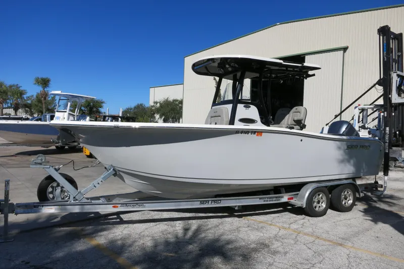 Slide: The Image of 2021 Sea Pro 239 Deep V CC boat on trailer, parked outdoors under clear blue sky. - 47