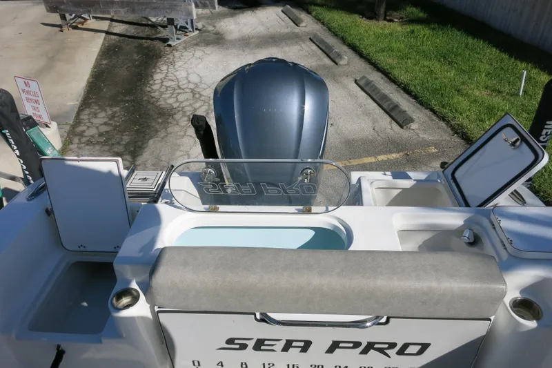 Slide: The Image of 2021 Sea Pro 239 Deep V CC boat with open storage compartments and visible outboard motor. - 56