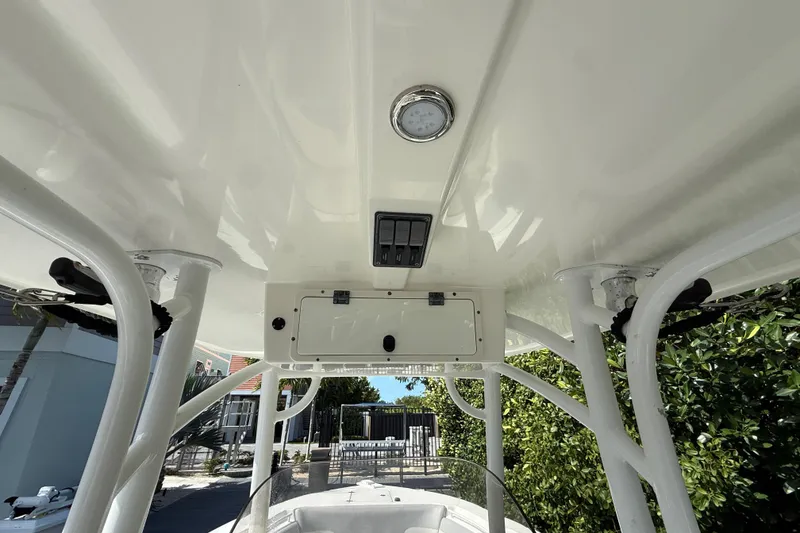 Slide: The Image of 2018 NauticStar 28 XS boat interior, featuring a sleek white console and overhead storage. - 18