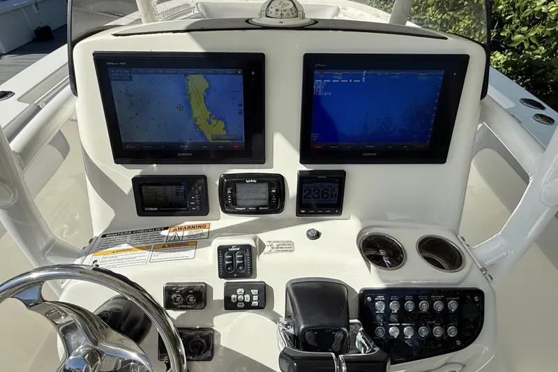 Slide: The Image of 2018 NauticStar 28 XS boat dashboard with dual Garmin displays and control panel. - 19