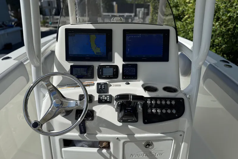 Slide: The Image of 2018 NauticStar 28 XS boat dashboard with steering wheel and navigation screens. - 20