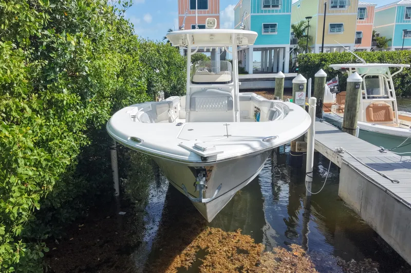 Slide: The Image of 2018 NauticStar 28 XS boat docked near colorful waterfront homes. - 3