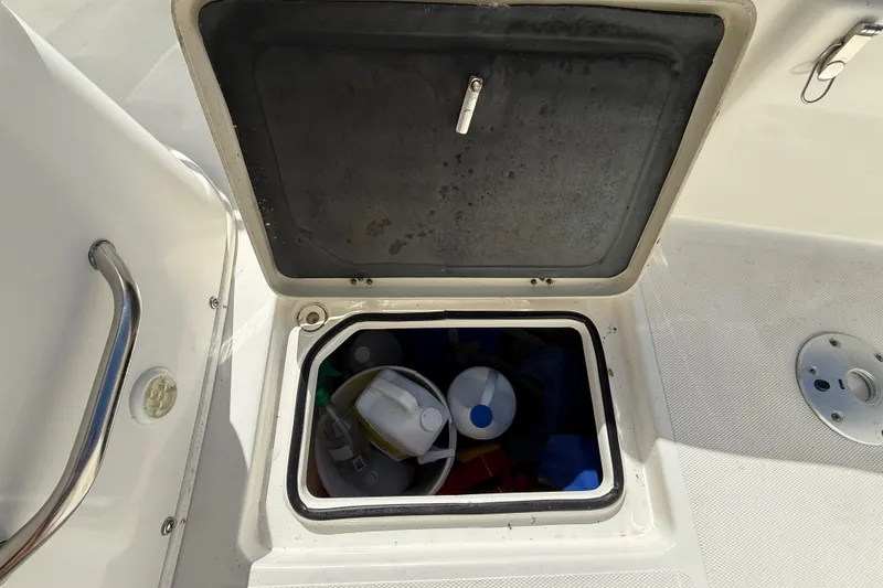 Slide: The Image of Open storage compartment on 2018 NauticStar 28 XS boat, containing various items. - 32