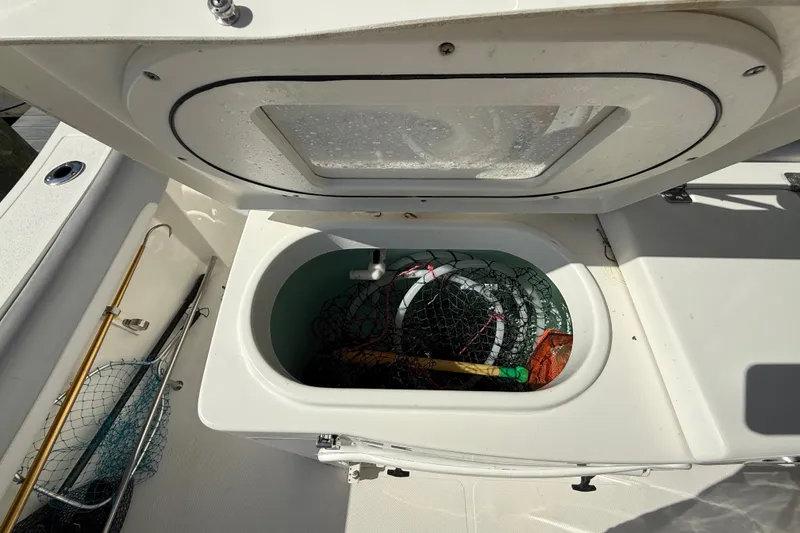 Slide: The Image of Open storage compartment on 2018 NauticStar 28 XS boat with fishing gear inside. - 36