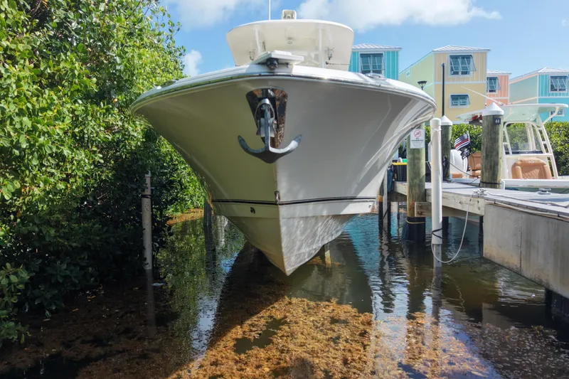 Slide: The Image of 2018 NauticStar 28 XS boat docked near colorful waterfront homes. - 4